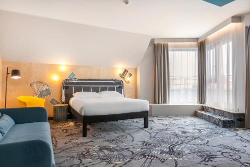 een slaapkamer met een bed, een bank en een open haard bij ibis Styles Szczecin Stare Miasto in Szczecin