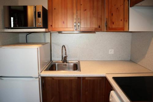 une petite cuisine avec un évier et un réfrigérateur dans l'établissement Résidence Le Belvedere - APPARTEMENT N° 601 LE BELVEDERE MAE-6784, aux Orres