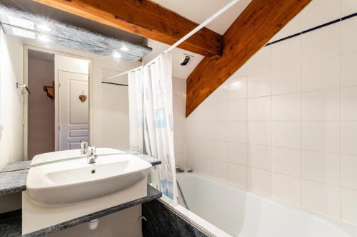 La salle de bains est pourvue d'un lavabo et d'une baignoire. dans l'établissement Résidence les Chalets D'aurouze - maeva Home - Appartement 2 Pièces 4 Perso 01, à Saint-Étienne-en-Dévoluy