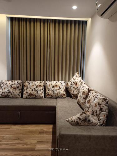 a couch with pillows on it in front of a window at Pinnacle Grand Hotel in Ahmedabad