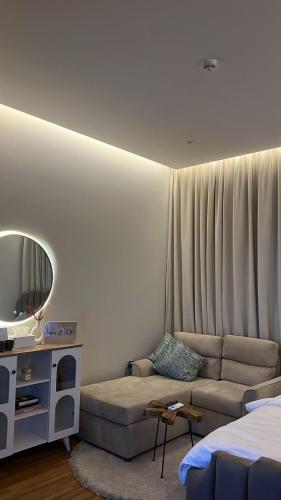 uma sala de estar com um sofá e um espelho em استديو انيق بدخول ذاتي مستقل em Riade