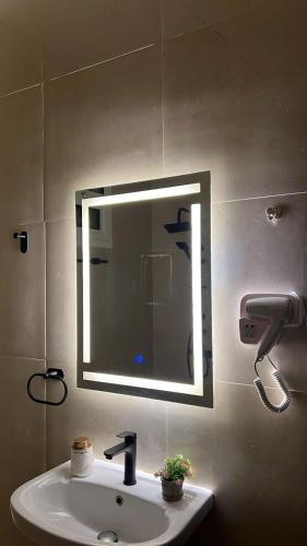 um lavatório de casa de banho com um espelho na parede em استديو انيق بدخول ذاتي مستقل em Riade