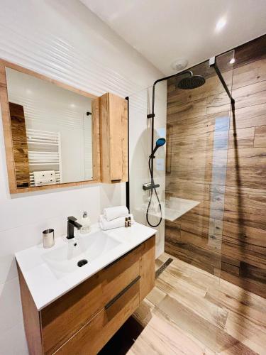 une salle de bain avec un lavabo et une douche dans l'établissement La Brimbelle - Hypercentre rue piétonne, à Gérardmer