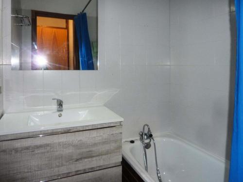 une personne prenant une photo d'une salle de bains avec baignoire et lavabo dans l'établissement Résidence Le Cairn - Studio 4/6 personnes MAE-7344, aux Orres