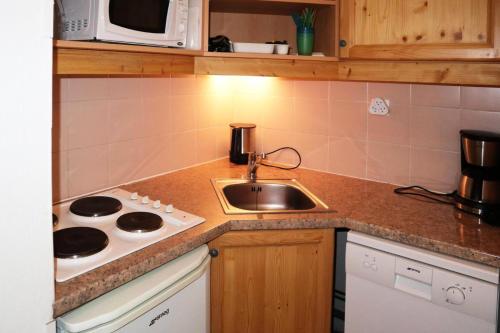 une petite cuisine avec un évier et une cuisinière dans l'établissement Résidence L'edelweiss - Joli appartement 2 pièces 6 personnes au cœur de station MAE-6764, aux Orres