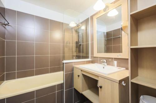 a bathroom with a sink and a toilet and a mirror at Résidence Les Bergers - maeva Home - Studio Sélection (6 personnes) 38 in LʼHuez