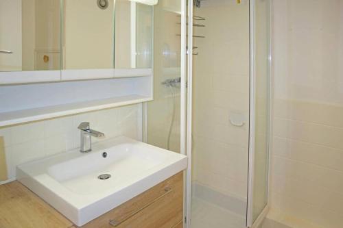 W łazience znajduje się biała umywalka i prysznic. w obiekcie Résidence Les Carlines - Studio pour 4 Personnes 264 w mieście Les Orres