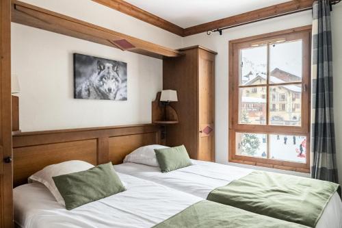 une chambre avec un lit et une fenêtre dans l'établissement Résidence Les Arcs 1950 Le Village - maeva Home - Appartement 3 Pièces 6 Personnes - Prestige MAE-2662, à Bourg-Saint-Maurice