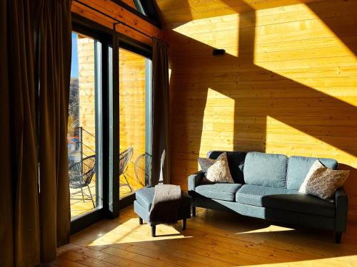 a living room with a couch and a large window at Woodland Noszvaj in Noszvaj