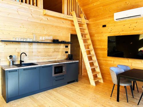 una cocina con fregadero y una escalera en una cabaña en Woodland Noszvaj, en Noszvaj
