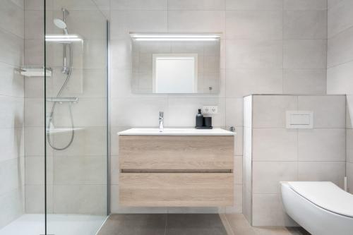 a white bathroom with a sink and a shower at Chic 3BR Penthouse with Balcony and Smart TV in Esch-sur-Alzette