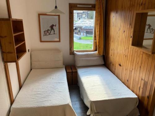deux lits dans une petite pièce avec une fenêtre dans l'établissement Quartier Crève Cœur - maeva Home - Studio 5 personnes Sélection MAE-2906, à Valmorel
