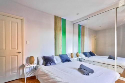 1 dormitorio con 2 camas y espejo en Charming 2 Bedroom House Surry Hills en Sídney