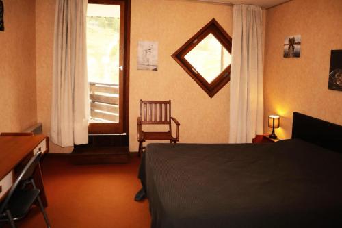 - une chambre avec un lit, une fenêtre et une chaise dans l'établissement Résidence Les Carlines - 2 Pièces pour 6 Personnes 284, à Le Mélézet