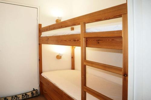 a room with two bunk beds and a mirror at Résidence Les Carlines - Studio pour 4 Personnes 194 in Le Mélézet