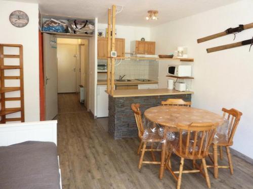 a kitchen and dining room with a table and chairs at Résidence Les Carlines - Studio pour 4 Personnes 234 in Le Mélézet