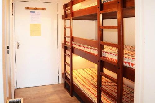 Pokój z łóżkiem piętrowym z 2 łóżkami piętrowymi i drzwiami w obiekcie Résidence Les Carlines - Studio pour 4 Personnes 274 w mieście Le Mélézet
