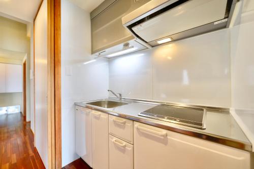 a kitchen with a sink and a stove at Starsビーチまで徒歩2分 古宇利島の自然に囲まれた非日常体験 in Nakijin