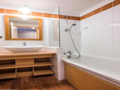 La salle de bains est pourvue d'un lavabo, d'une douche et d'une baignoire. dans l'établissement DORONIC - Appartement DORONIC 871 pour 4 Personnes 89, à Plagne 1800