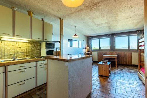a kitchen with white cabinets and a table in a room at LE VERCORS - Appartement VERCORS 111 pour 4 Personnes 98 in Plagne Villages