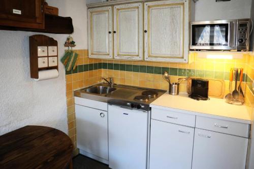 une petite cuisine avec un évier et un micro-ondes dans l'établissement Résidence Orr Des Neiges - Studio Les orres 1650 MAE-3974, à Le Mélézet