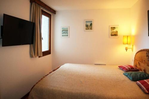 a bedroom with a bed and a flat screen tv at Résidence Le Belvedere - APPARTEMENT N° 401 LE BELVEDERE MAE-4014 in Le Mélézet