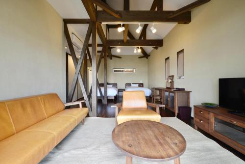 a living room with a couch and a table at Starsビーチまで徒歩2分 古宇利島の自然に囲まれた非日常体験 in Nakijin