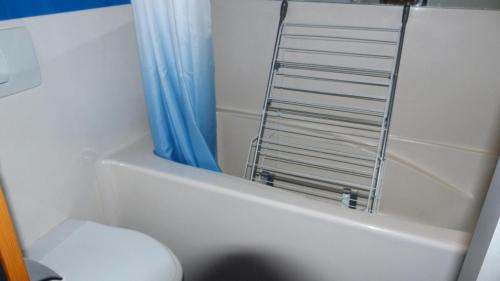 La salle de bains est pourvue d'une baignoire, de toilettes et d'un sèche-serviettes. dans l'établissement Résidence Aiguille Grive Bat Ii - Appartement 2 pièces en duplex pour 5 personnes proche des pistes dans le village de Charmettoger à Arc 1800 MAE-2075, à Arc 1800