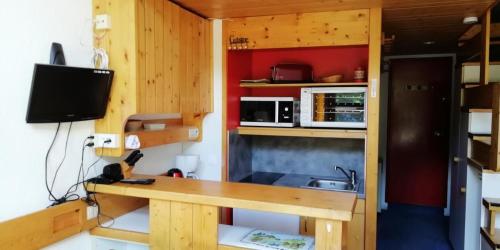 Elle comprend une petite cuisine avec un bureau et un évier. dans l'établissement Résidence Aiguille Grive Bat Ii - Appartement 2 pièces en duplex pour 5 personnes proche des pistes dans le village de Charmettoger à Arc 1800 MAE-2075, à Arc 1800