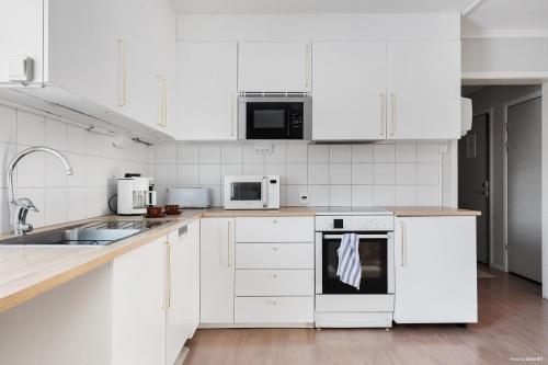 una cocina blanca con armarios y electrodomésticos blancos en Rum i Kalix en Kalix