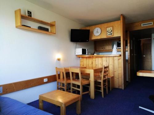 Cette chambre comprend une cuisine, une table et des chaises. dans l'établissement Résidence Lauzieres - Studio 5 personnes skis aux pieds et proche des commerces dans le village du Charvet à Arc 1800 MAE-2086, à Arc 1800