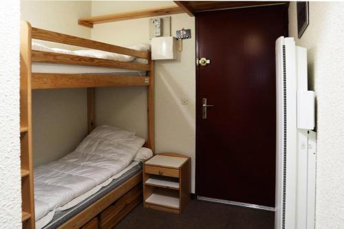 mały pokój z 2 łóżkami piętrowymi i drzwiami w obiekcie Résidence Balcon Orres - NOUVEAUTE confortable studio 4 personnes MAE-4144 w mieście Le Mélézet