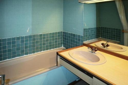 une salle de bain avec un lavabo, un miroir et une baignoire dans l'établissement Résidence Orr Des Forets - studio centre station MAE-4084, à Le Mélézet