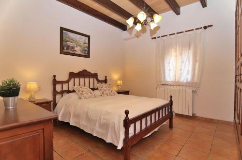 1 dormitorio con cama, escritorio y ventana en Finca Can Xisco Domatiga 250 by Mallorca Charme, en Ariany