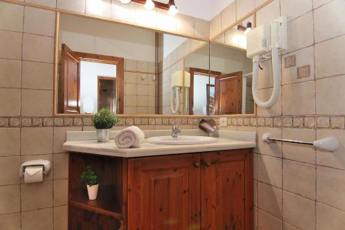 baño con lavabo y espejo grande en Finca Can Xisco Domatiga 250 by Mallorca Charme, en Ariany