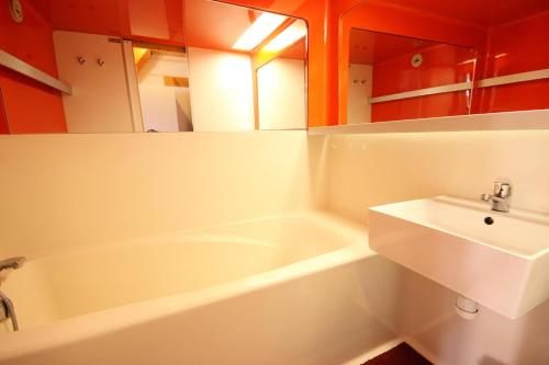 een badkamer met een wit bad en een wastafel bij Résidence Arc En Ciel - 2 Pièces pour 5 Personnes 63 in Peisey-Nancroix