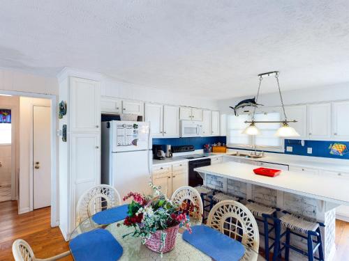a kitchen with blue cabinets and a white refrigerator at Crews Nest in Cherry Grove in Myrtle Beach