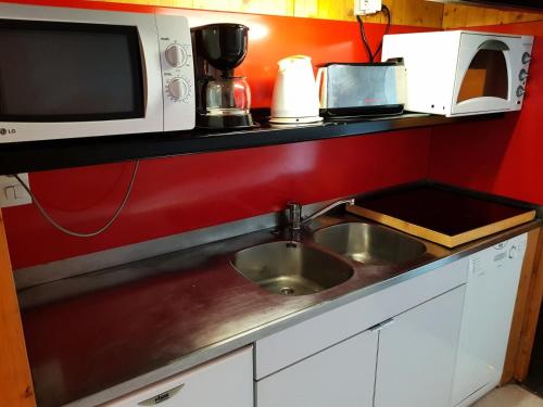 un comptoir de cuisine avec un évier et un micro-ondes dans l'établissement Résidence Cascade - Grand studio 4 personnes à Arc 1600 ski aux pieds et proche des commerces MAE-2100, à Arc 1600