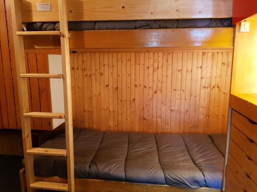 a bunk bed in a room with wooden walls at Résidence Cascade - Studio pour 4 Personnes 00 in Arc 1600
