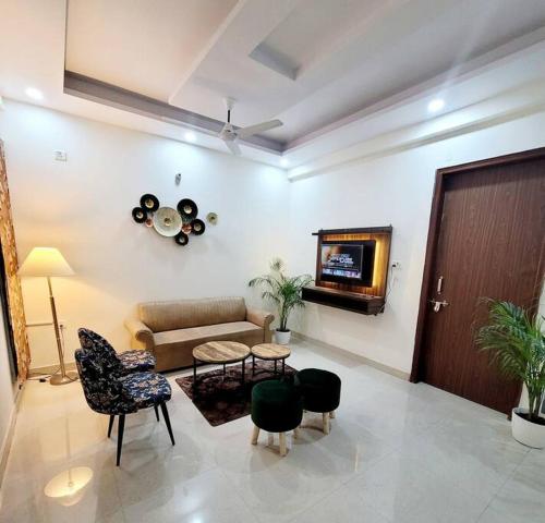 ein Wohnzimmer mit einem Sofa und einem TV in der Unterkunft Blisś 3.0 1Bedroom+Living Room+kitchen in Noida 63 in Noida