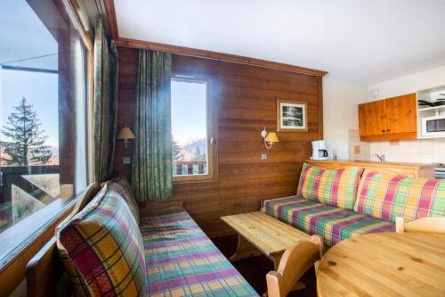 une chambre avec un canapé, une table et une fenêtre dans l'établissement Quartier Crève Cœur - maeva Home - 2 Pièces 5 Personnes Confort MAE-5851, à Valmorel