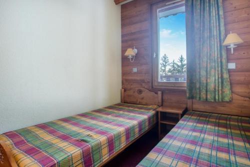 une petite chambre avec deux lits et une fenêtre dans l'établissement Quartier Crève Cœur - maeva Home - 2 Pièces 5 Personnes Confort MAE-5851, à Valmorel