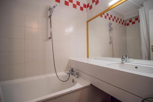 a bathroom with a tub and a sink and a shower at PORTAIL G - Appartement PORTAIL 73 pour 4 Personnes 63 in Valmorel