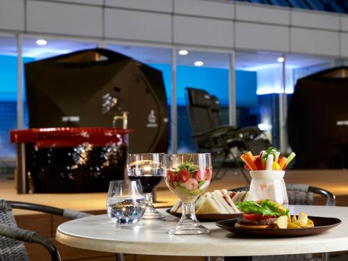 a table with a plate of food and wine glasses at Miyako Hotel Gifu Nagaragawa in Gifu