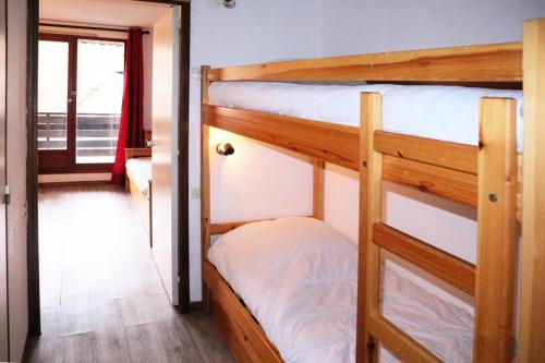 two bunk beds in a room with a window at Résidence Le Pouzenc - Studio pour 4 Personnes 824 in Le Mélézet