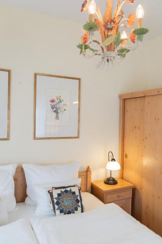 a bedroom with a bed and a chandelier at Gästehaus Englischer Garten in Munich