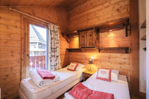 Habitación con 2 camas en una cabaña de madera en Résidence Les Alpages de Reberty - maeva Home - Appartement 3 pièces 8 pers 49 en Les Menuires