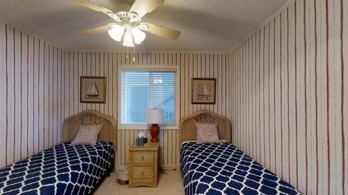 a bedroom with two beds and a ceiling fan at Beachmaster Unit 107 in Cherry Grove is an Oceanfront Condo in Myrtle Beach