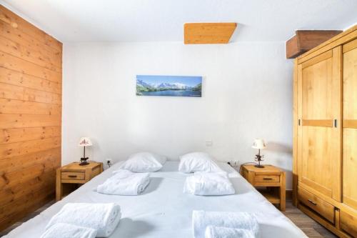 une chambre avec deux lits et deux tables de nuit dans l'établissement Résidence Les Alpages de Chantel - maeva Home - Appartement 2 pièces 6 personnes - Sélection MAE-6909, à Bourg-Saint-Maurice