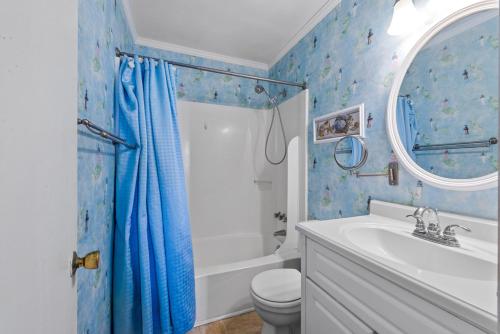 a bathroom with a toilet and a blue shower curtain at Sea Cabin Unit 125 Cherry Grove in Myrtle Beach